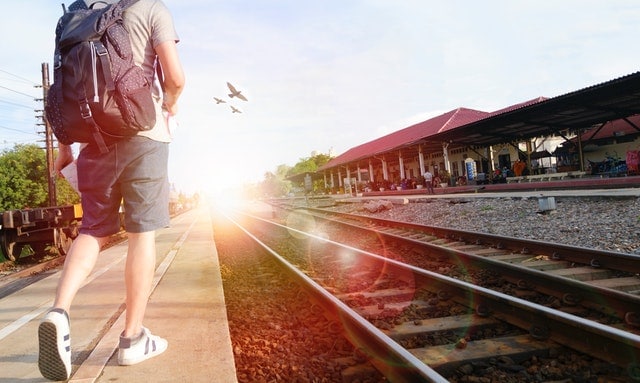 man walking at side of railroad