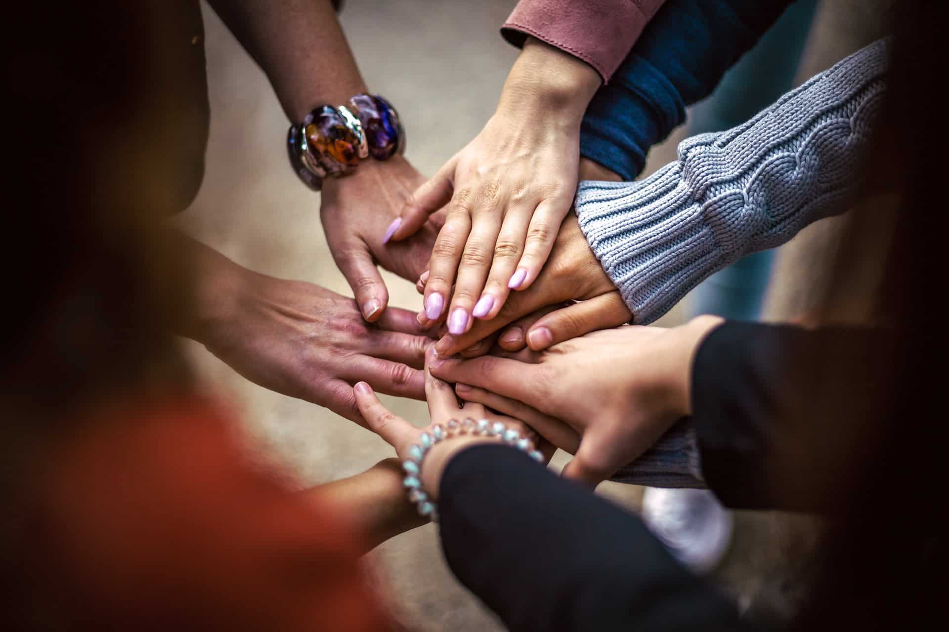 a group of people gathering hands teams